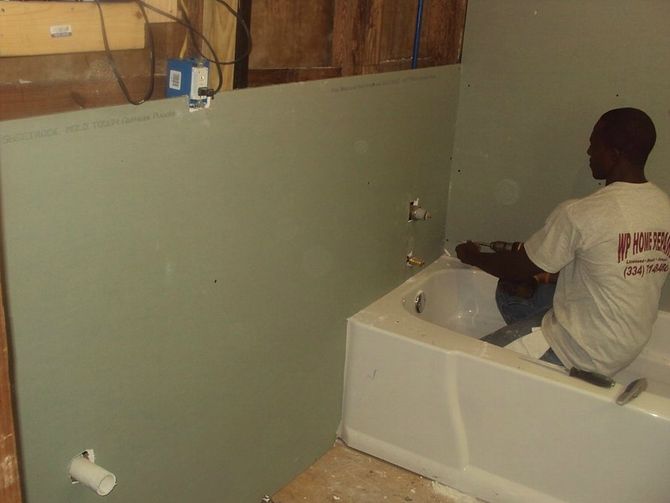 man fixing the plumbing for the tub