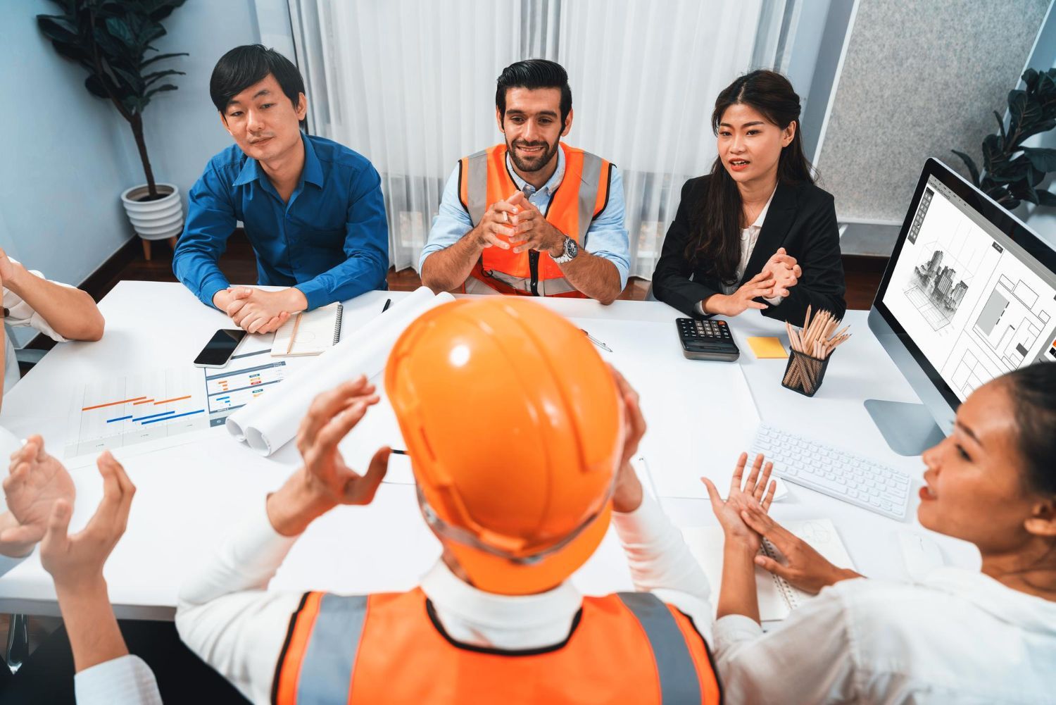 A group of construction workers are giving each other a high five.
