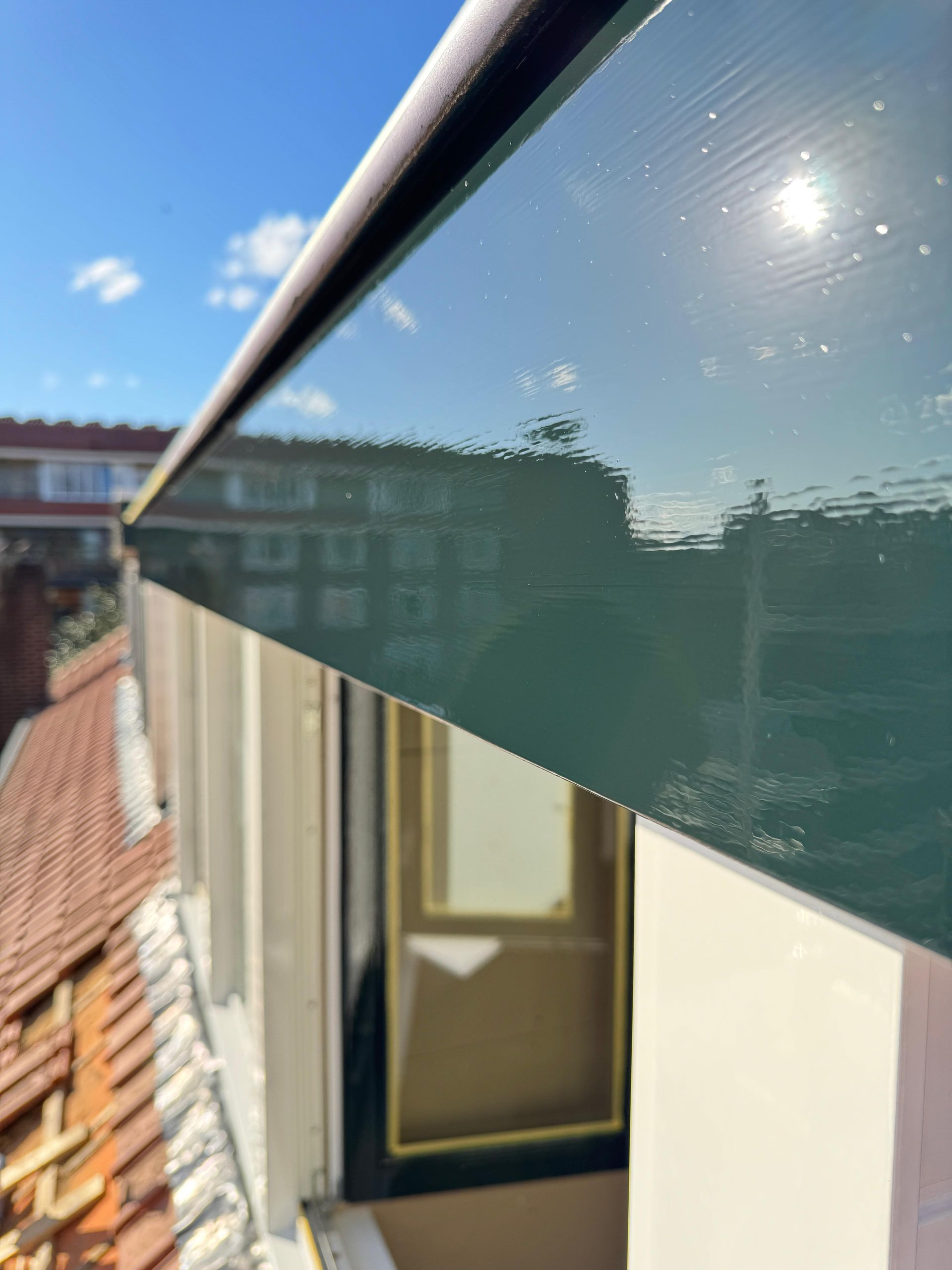 Een gebouw met een groene goot aan de zijkant.