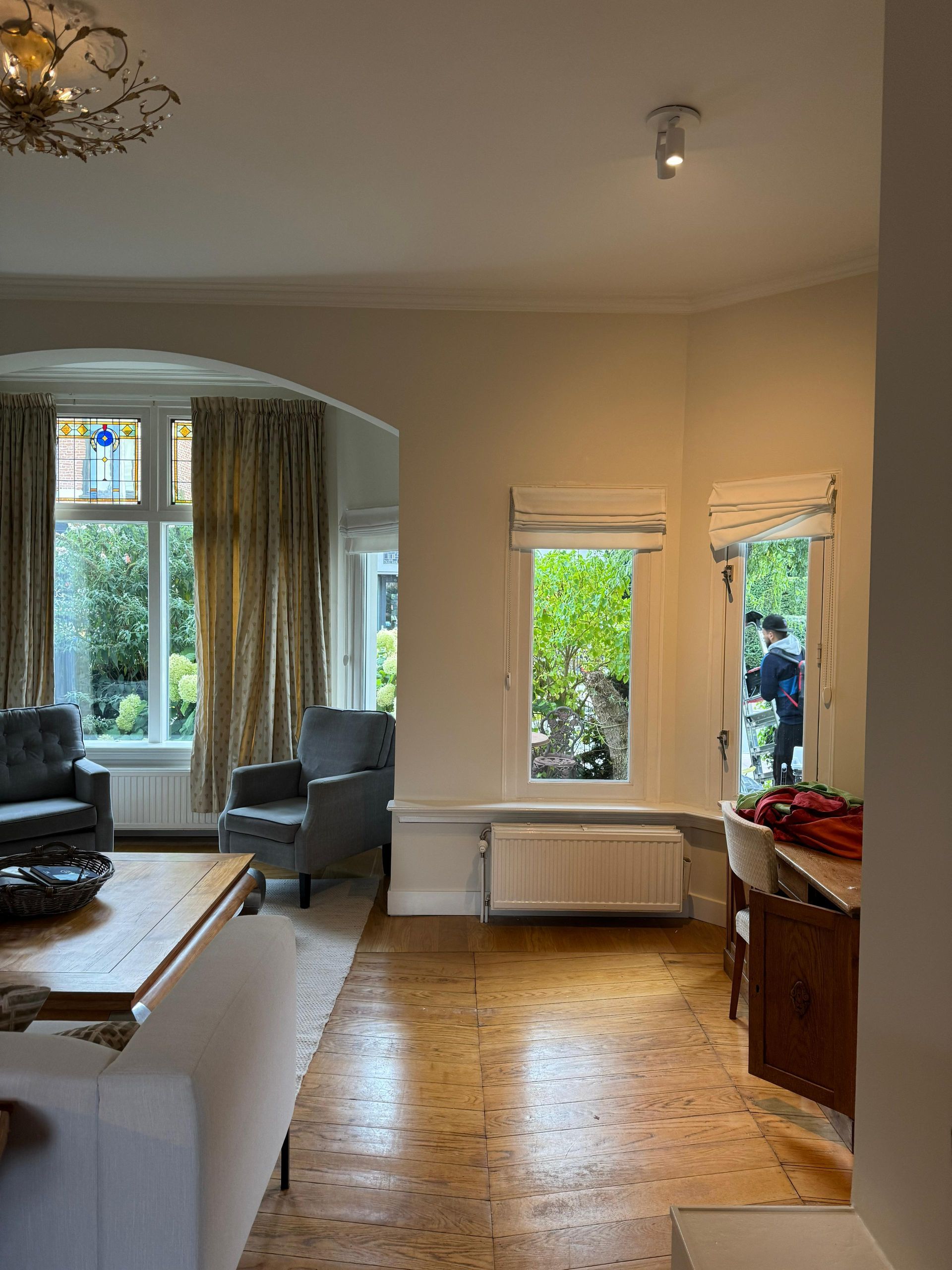 Een woonkamer met een bank, stoel, tafel en raam.