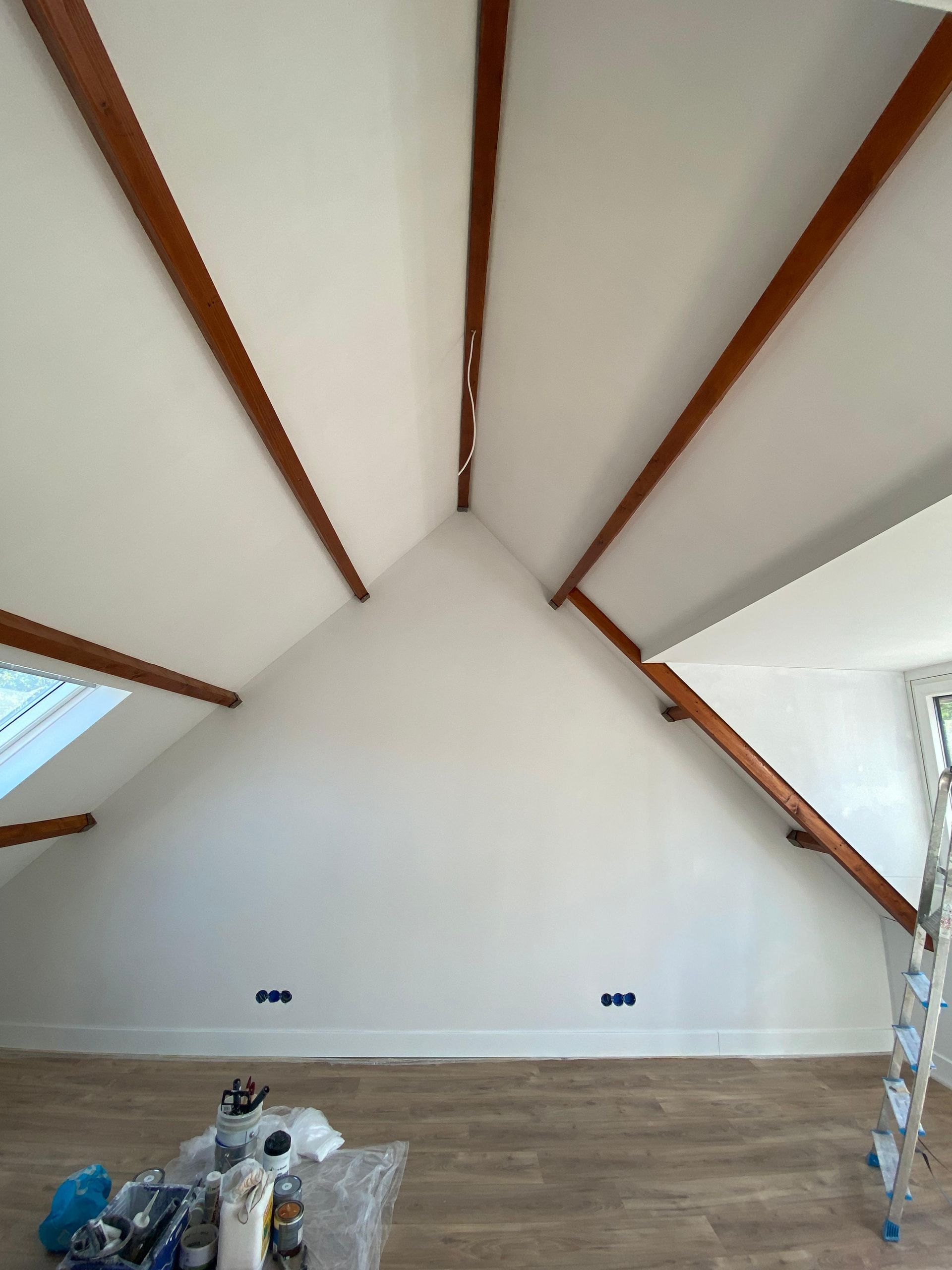 Een kamer met een gewelfd plafond en houten balken.