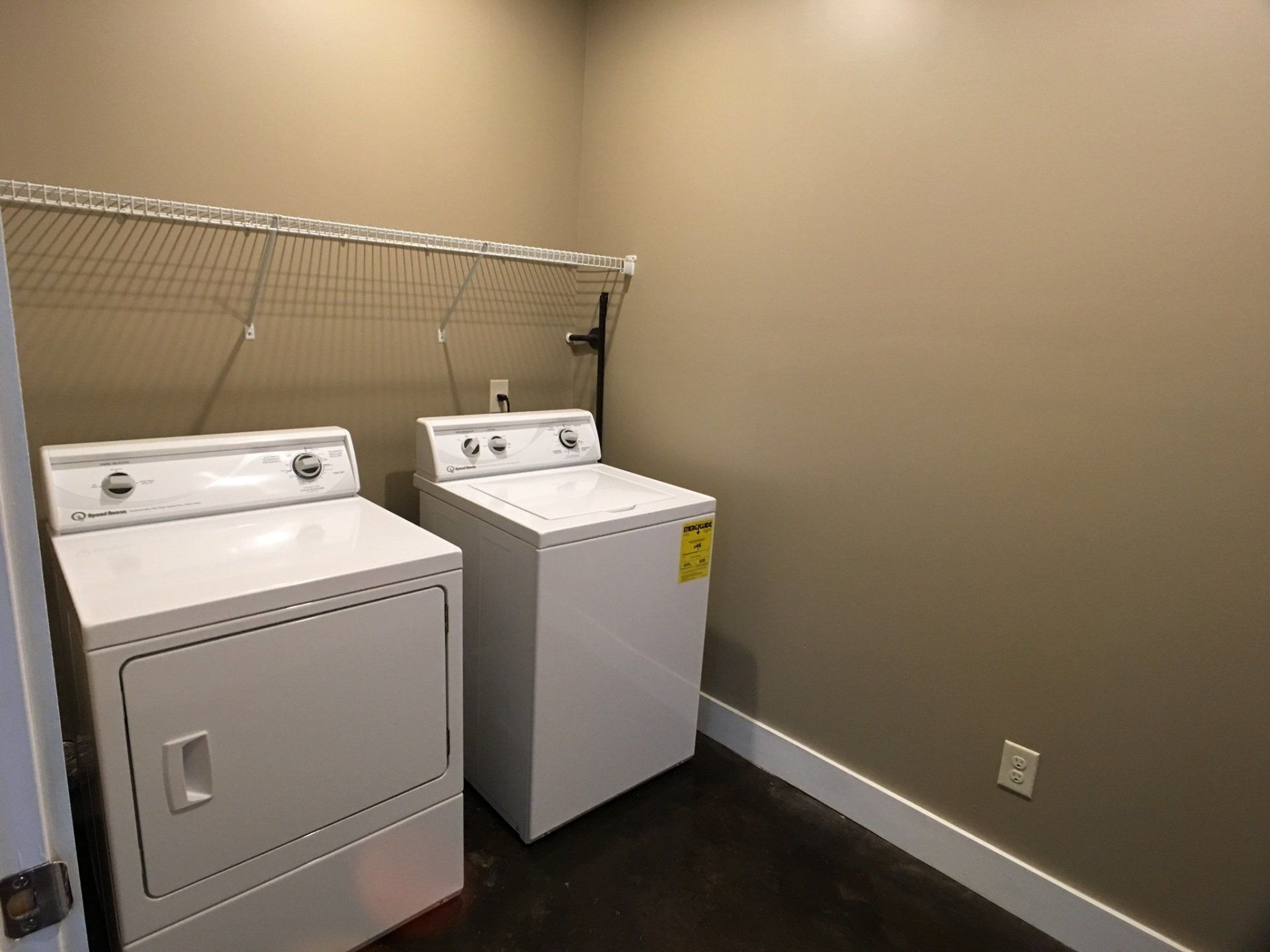 The laundy room complete with shelf and washer and dryer