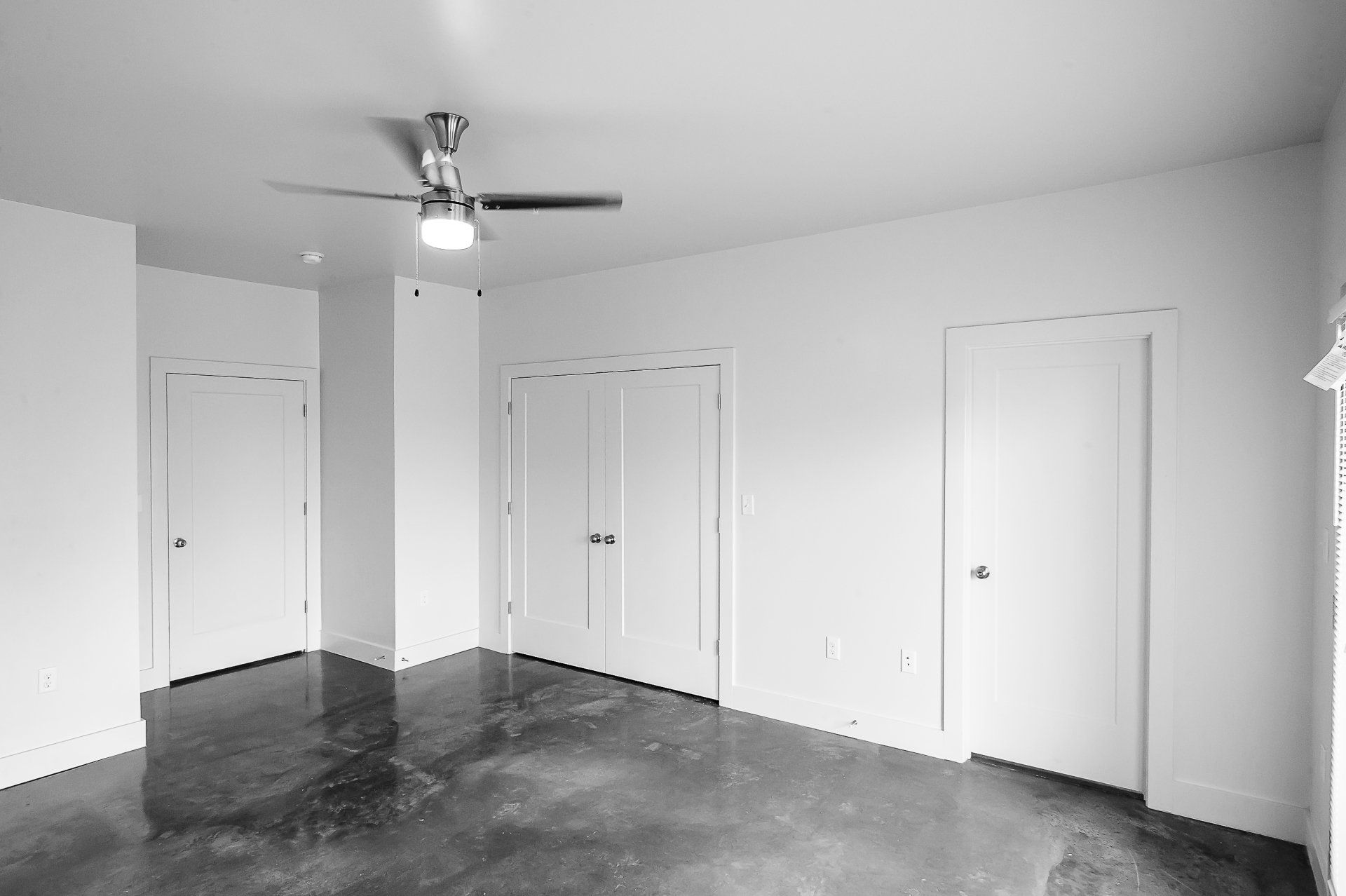 A large bedroom with modern ceiling fan