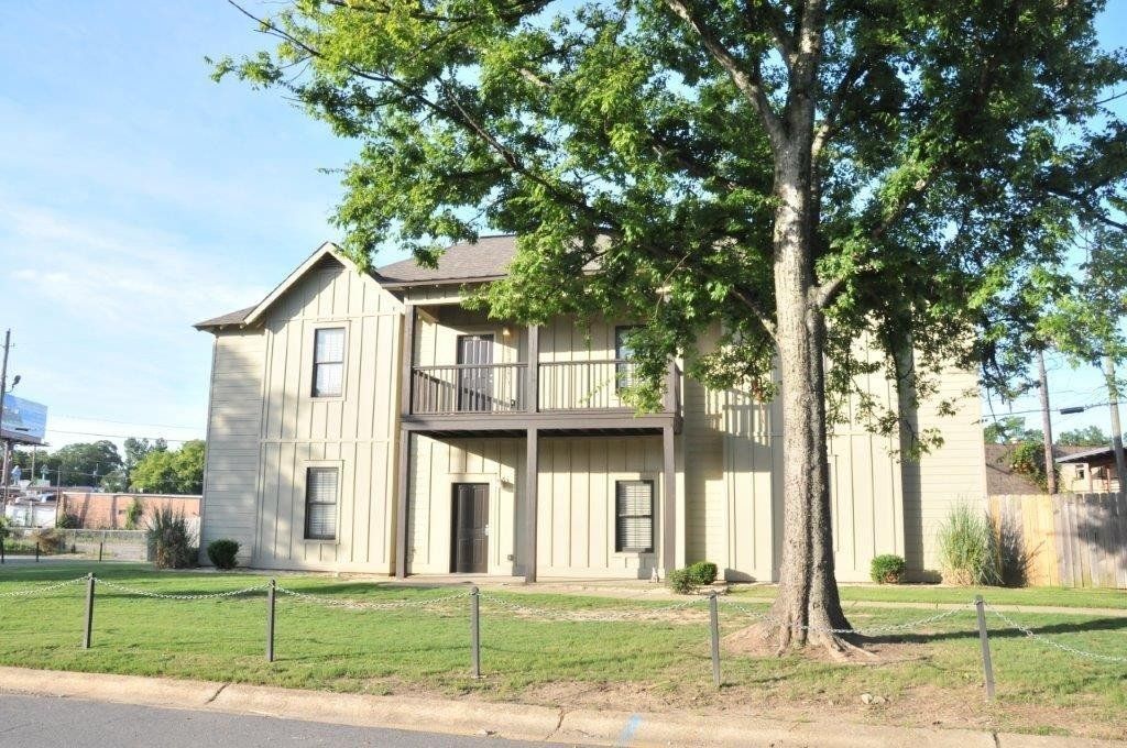Another exterior view with large tree and grassy area