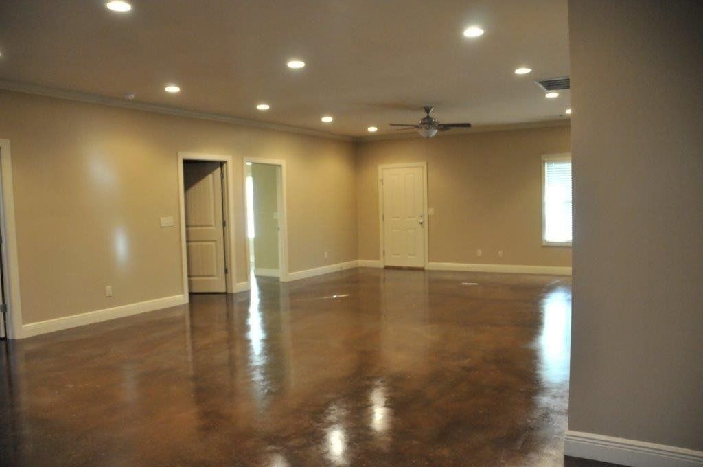 Another view of the large living room with doors into a bedroom and downstairs bathroom
