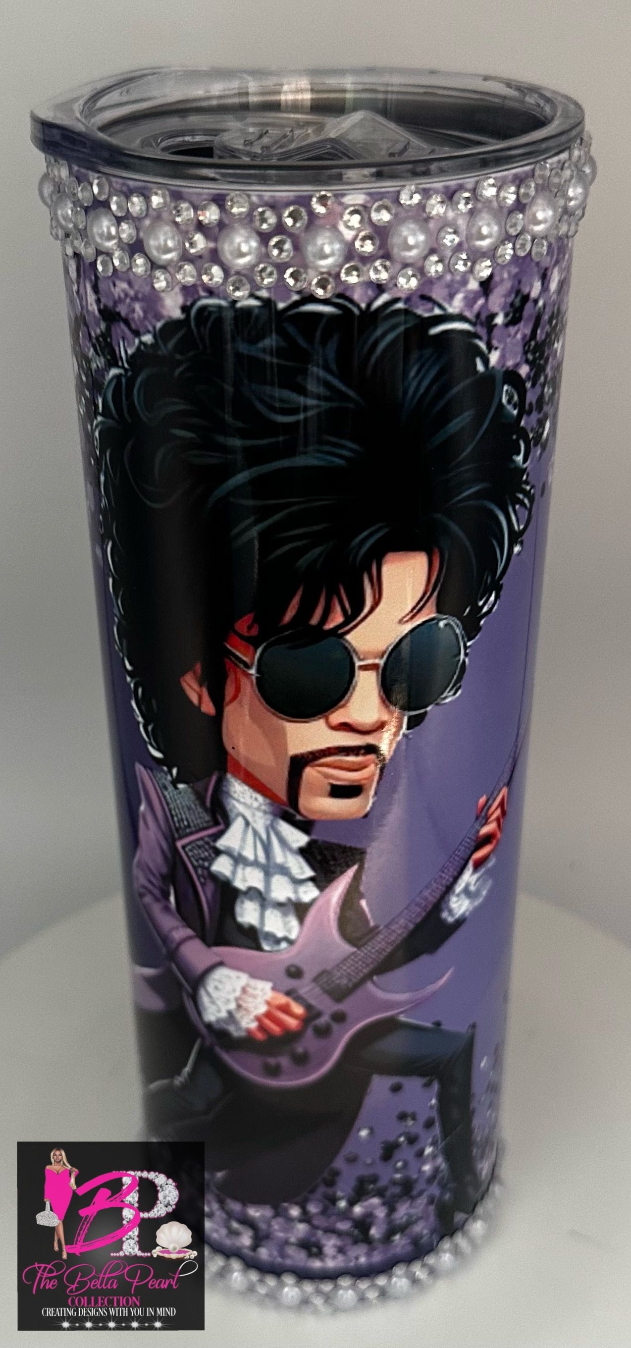 A stainless steel tumbler with a picture of prince playing a guitar.