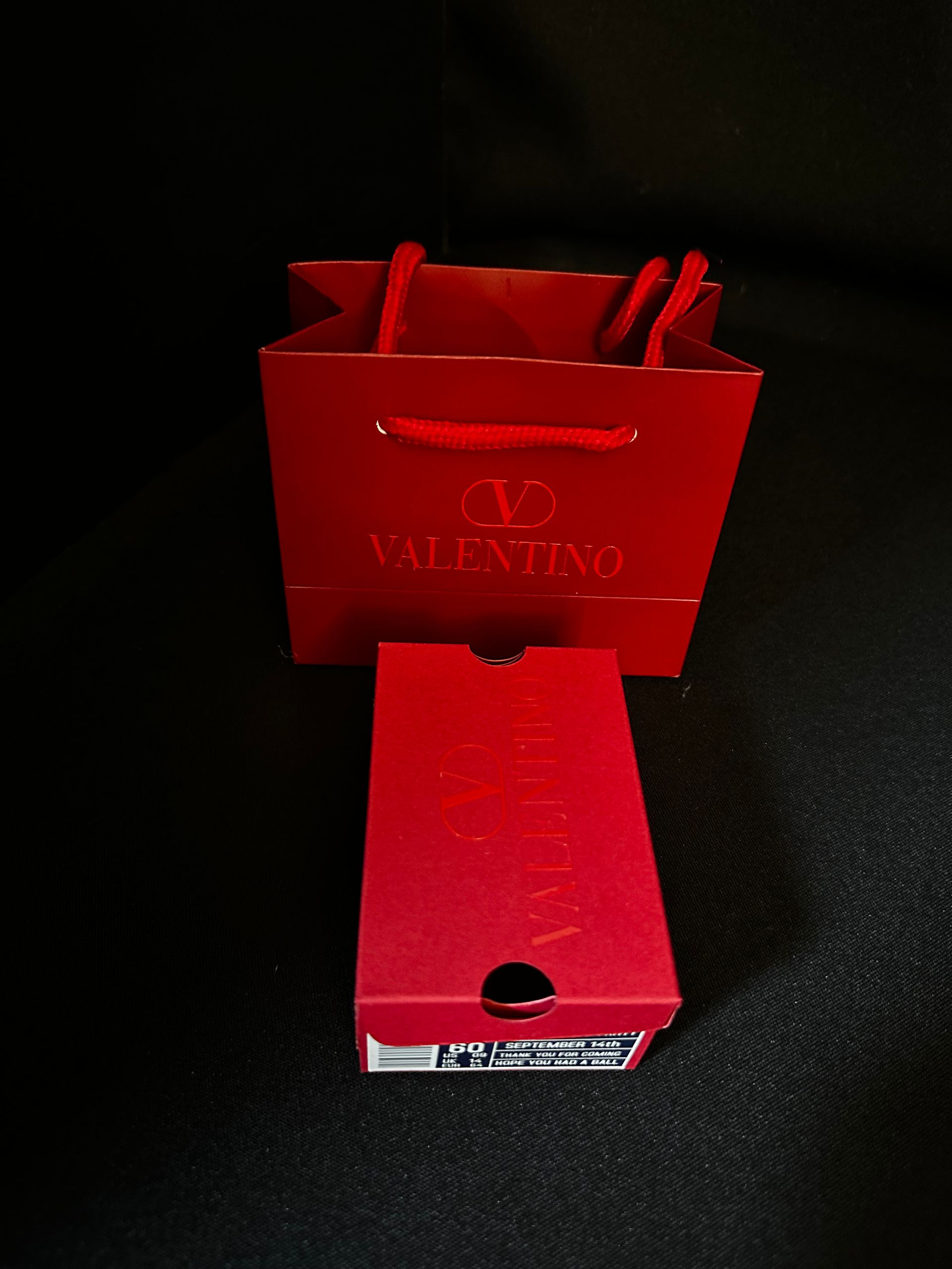 A red valentino favor bag sits next to a red box