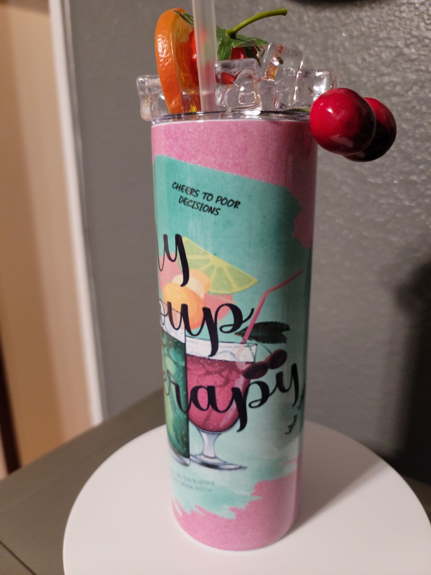 A pink stainless steel tumbler with a drink in it and a straw.