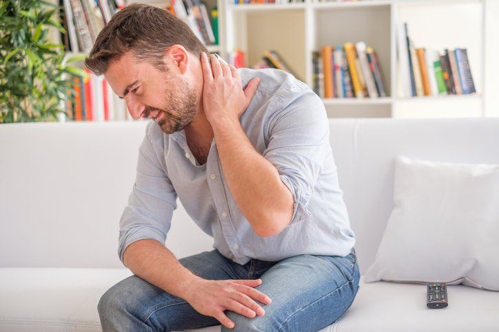 Man Feeling Neck Ache After Bad Posture — Dodge City, KS — Phillips Chiropractic & Physical Therapy Center