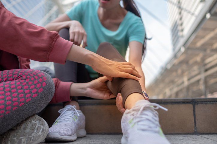 Runner Holding Painful Sprained Ankle — Dodge City, KS — Phillips Chiropractic & Physical Therapy Center