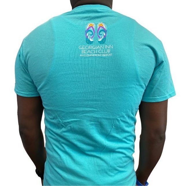 Back of a teal t-shirt featuring a beach-themed logo with flip-flops and the text 