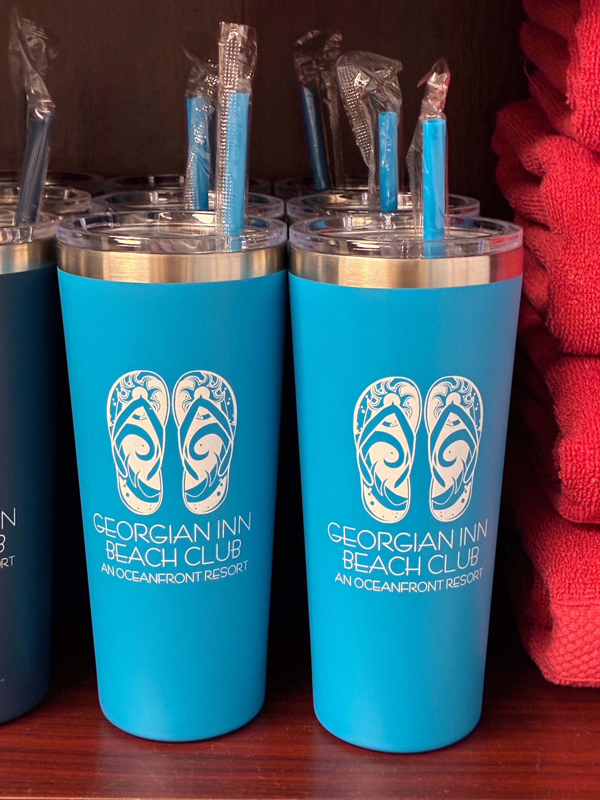 Two blue tumblers with white flip-flop logo, 
