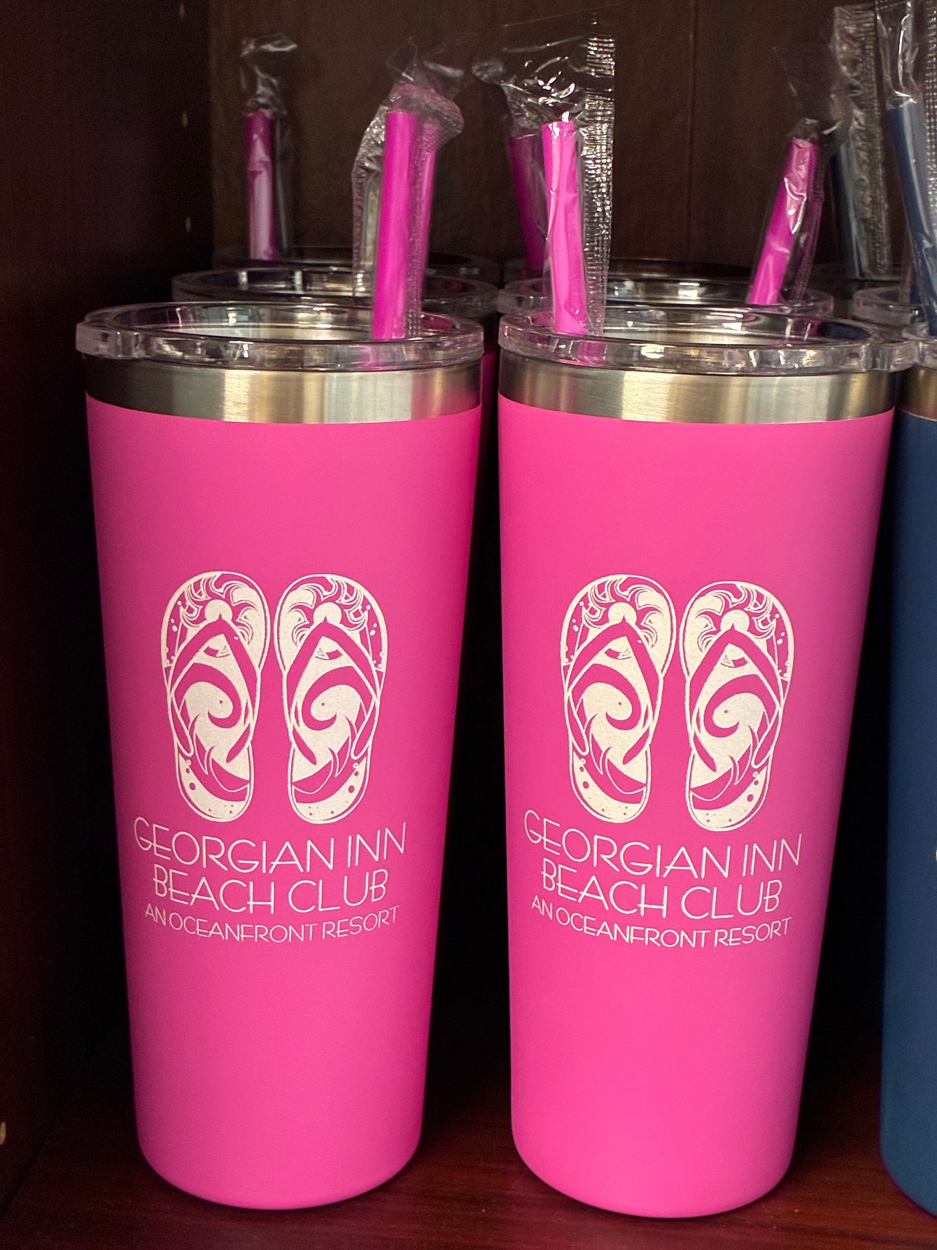 Two pink travel mugs with silver lids, pink straws, and white flip-flop design, labeled 