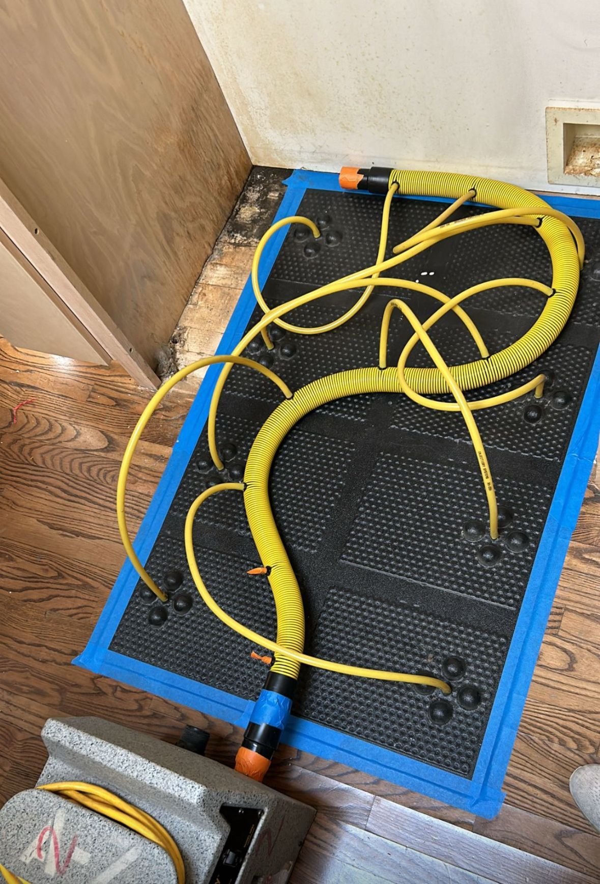 A bunch of yellow hoses are laying on the floor in a room.