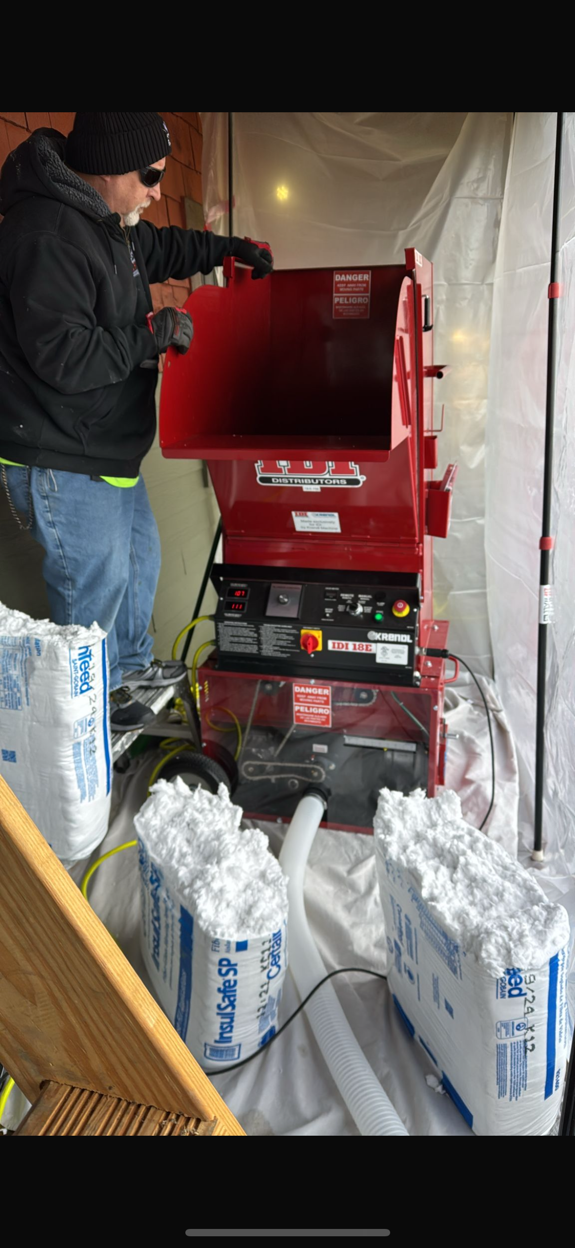 A man is using a drill to drill a hole in a piece of wood.