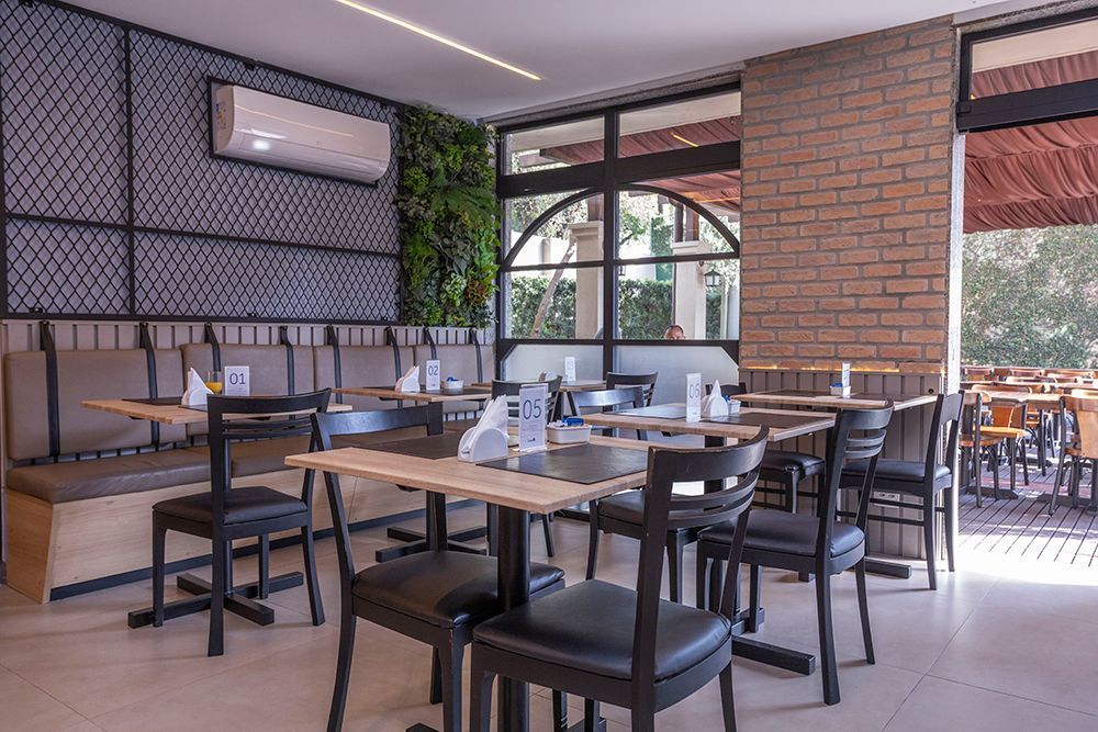 Uma sala com sofá, cadeiras, mesa e tapete de couro.