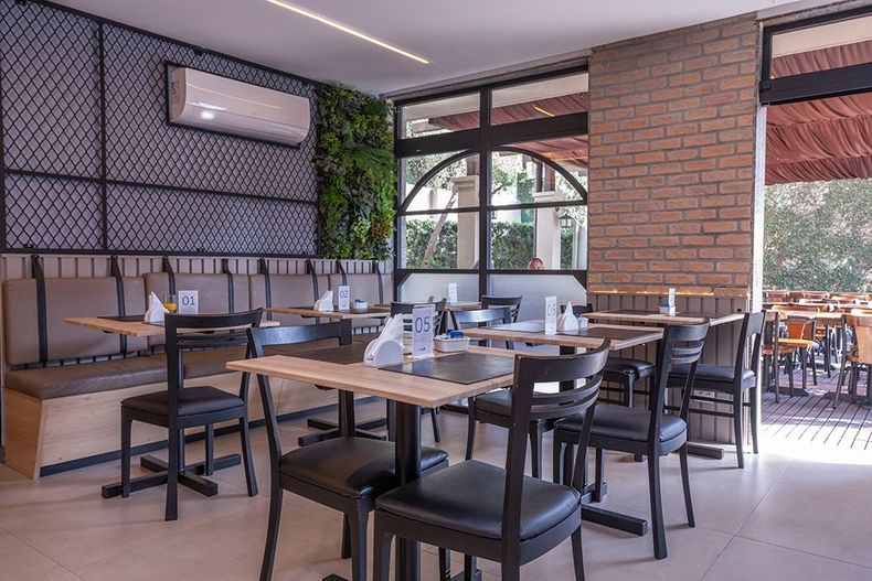 Uma sala com sofá, cadeiras, mesa e tapete de couro.