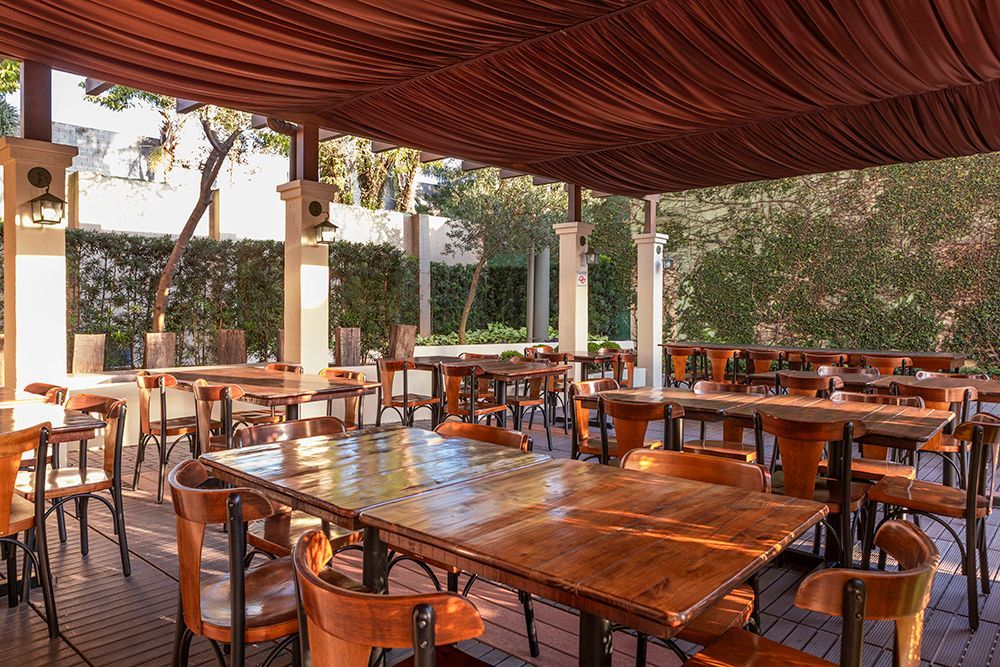 Uma grande sala cheia de mesas e cadeiras em um restaurante.