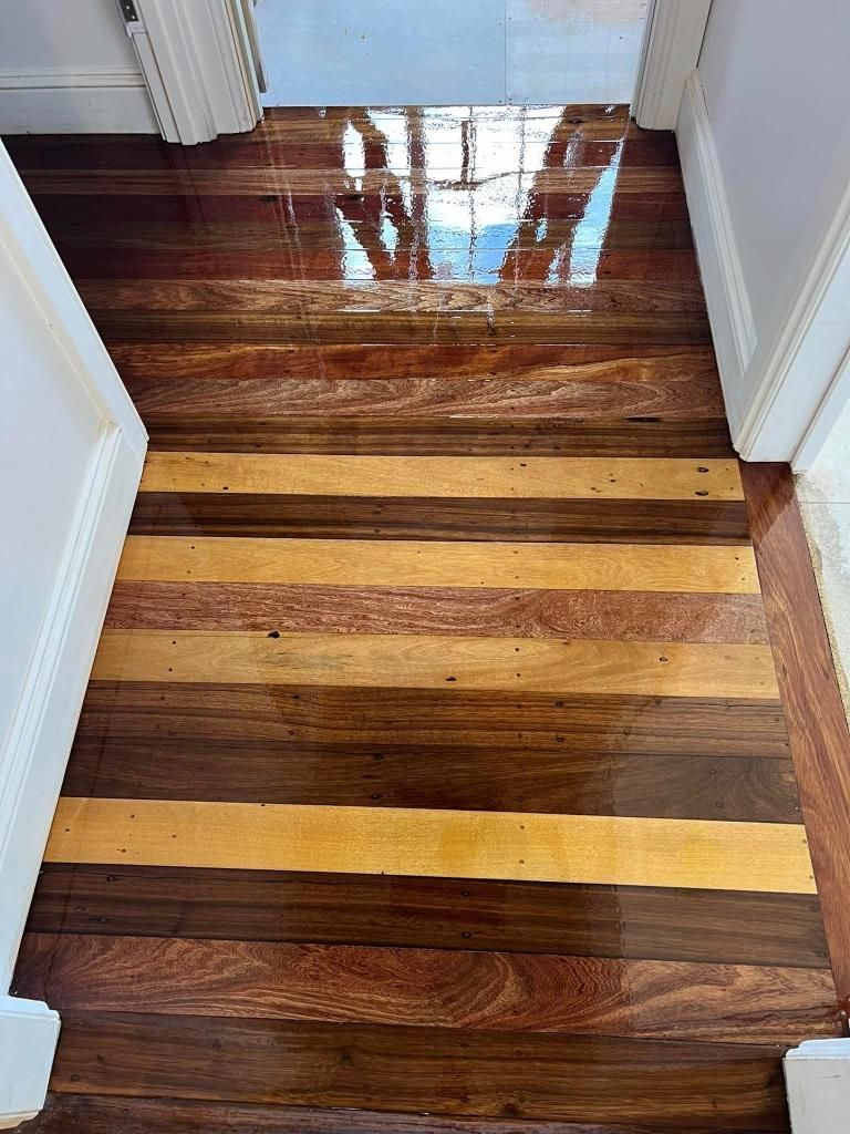 A Hallway With A Wooden Floor And Stairs Leading Up To A Door — AJ's Cleaning & Floor Sanding In Woree, QLD
