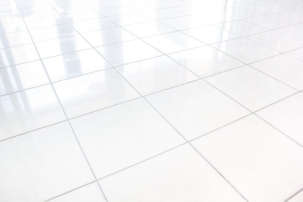 A Close Up Of A White Tiled Floor With A Reflection Of A Window — AJ's Cleaning & Floor Sanding In Woree, QLD