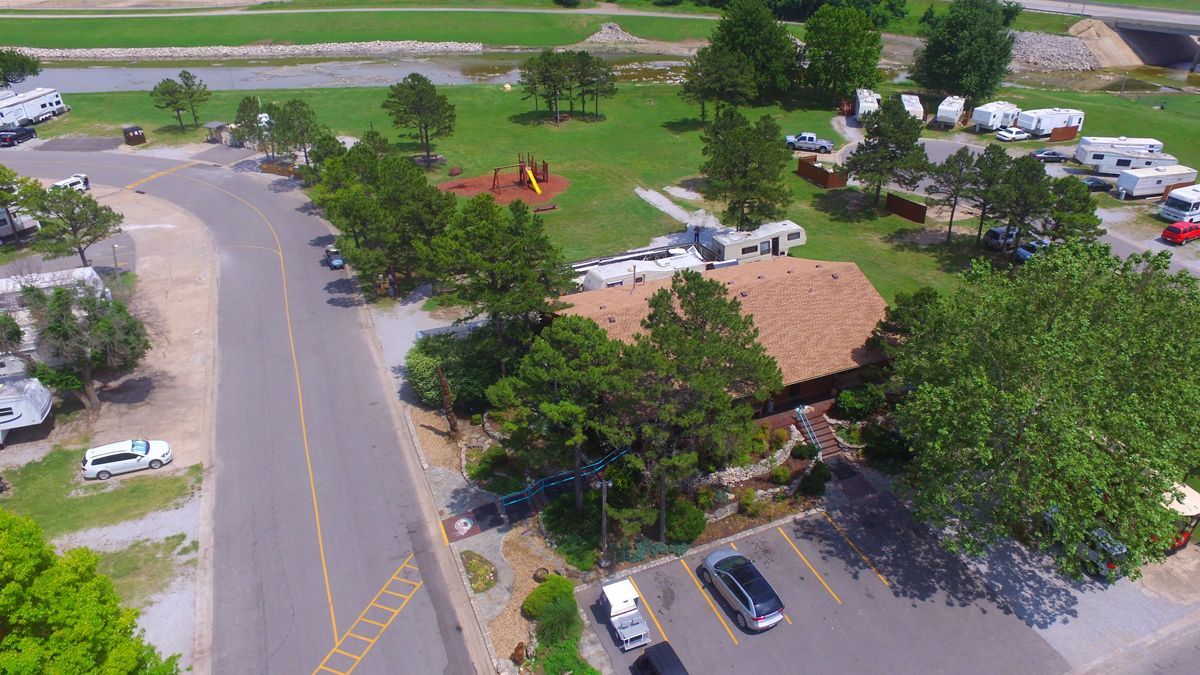 An aerial view of a park with a lot of cars parked in a parking lot.