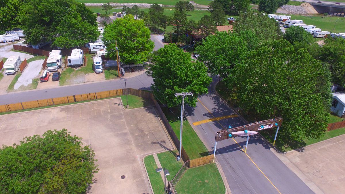 An aerial view of a park with a lot of trees and a road.