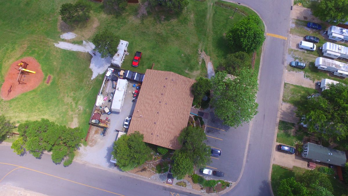 An aerial view of a park with a house and a playground.