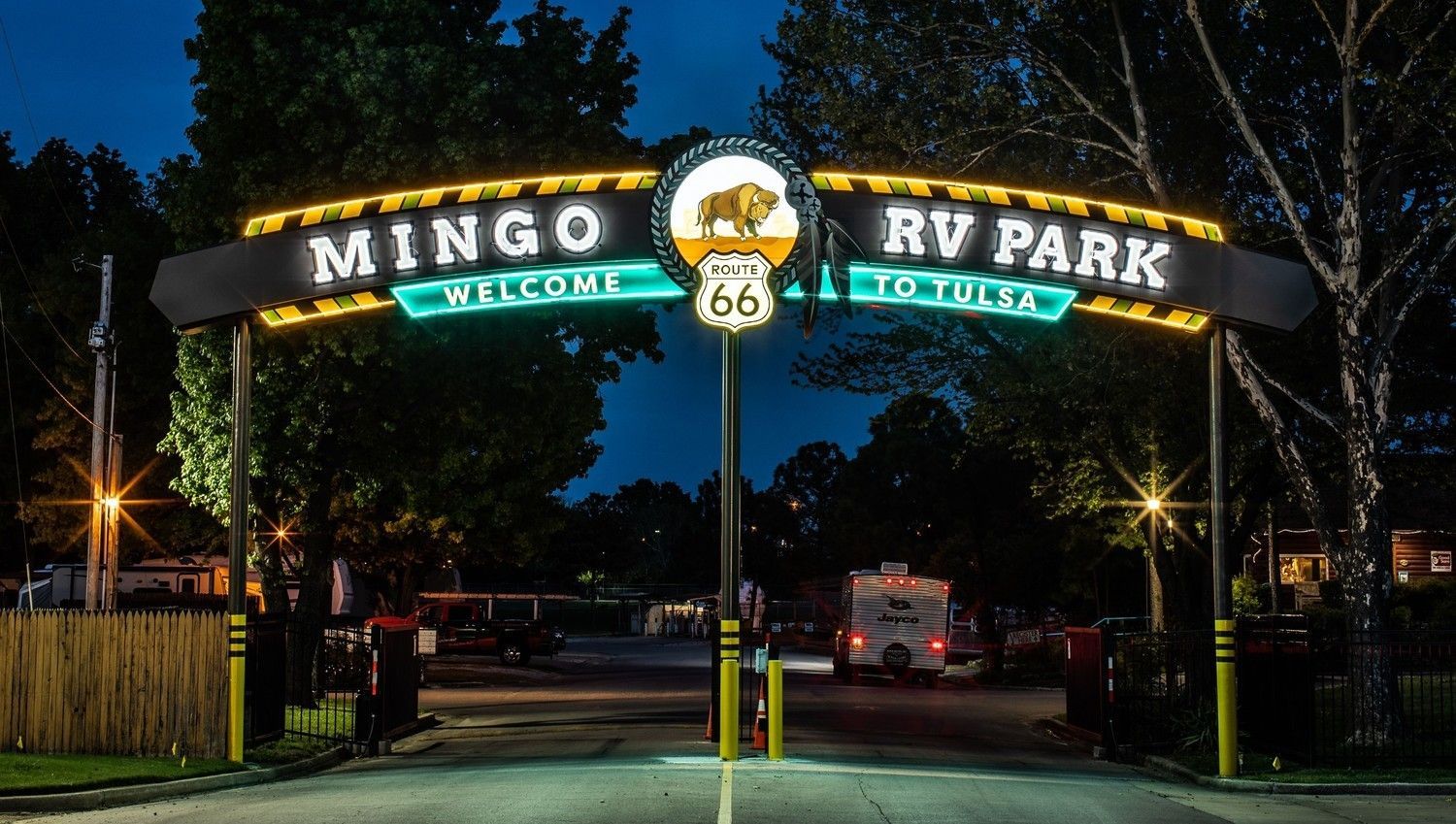 A sign for mingo rv park is lit up at night