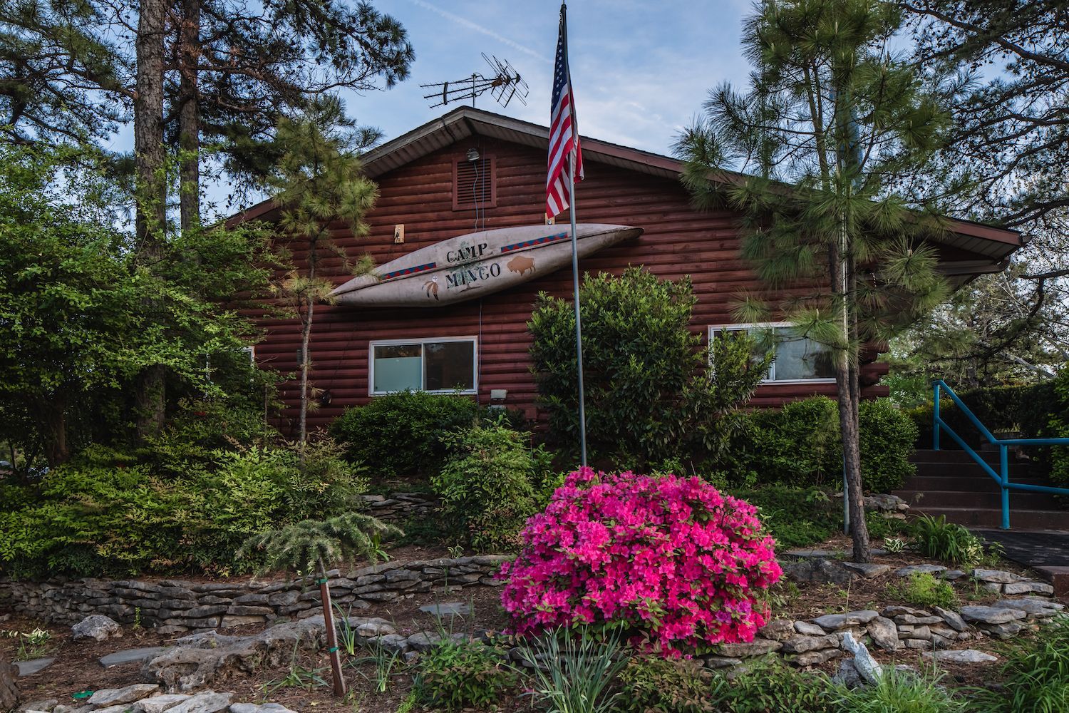 A house with a surfboard on the front of it and an american flag.