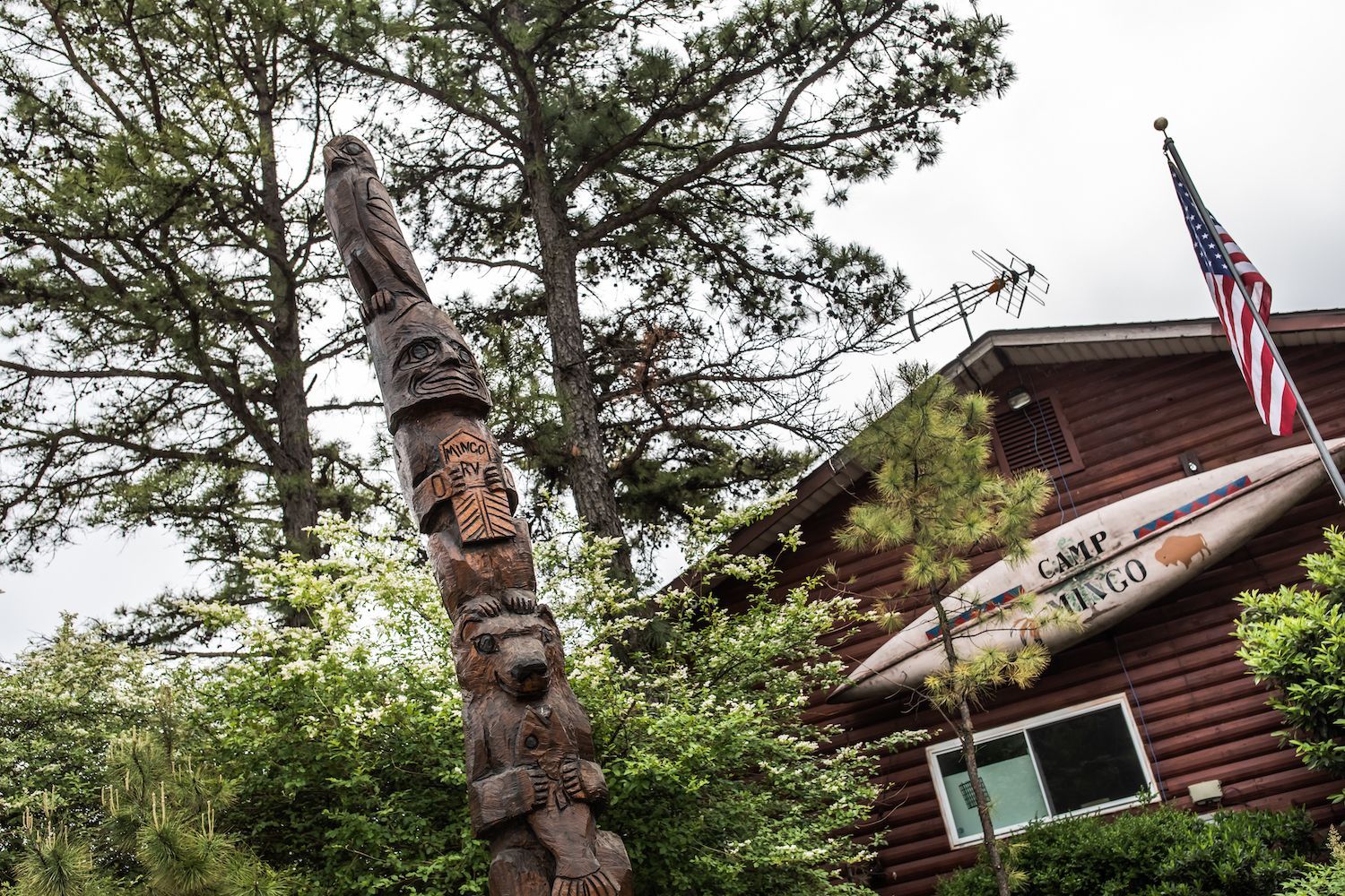 A wooden house with a totem pole in front of it