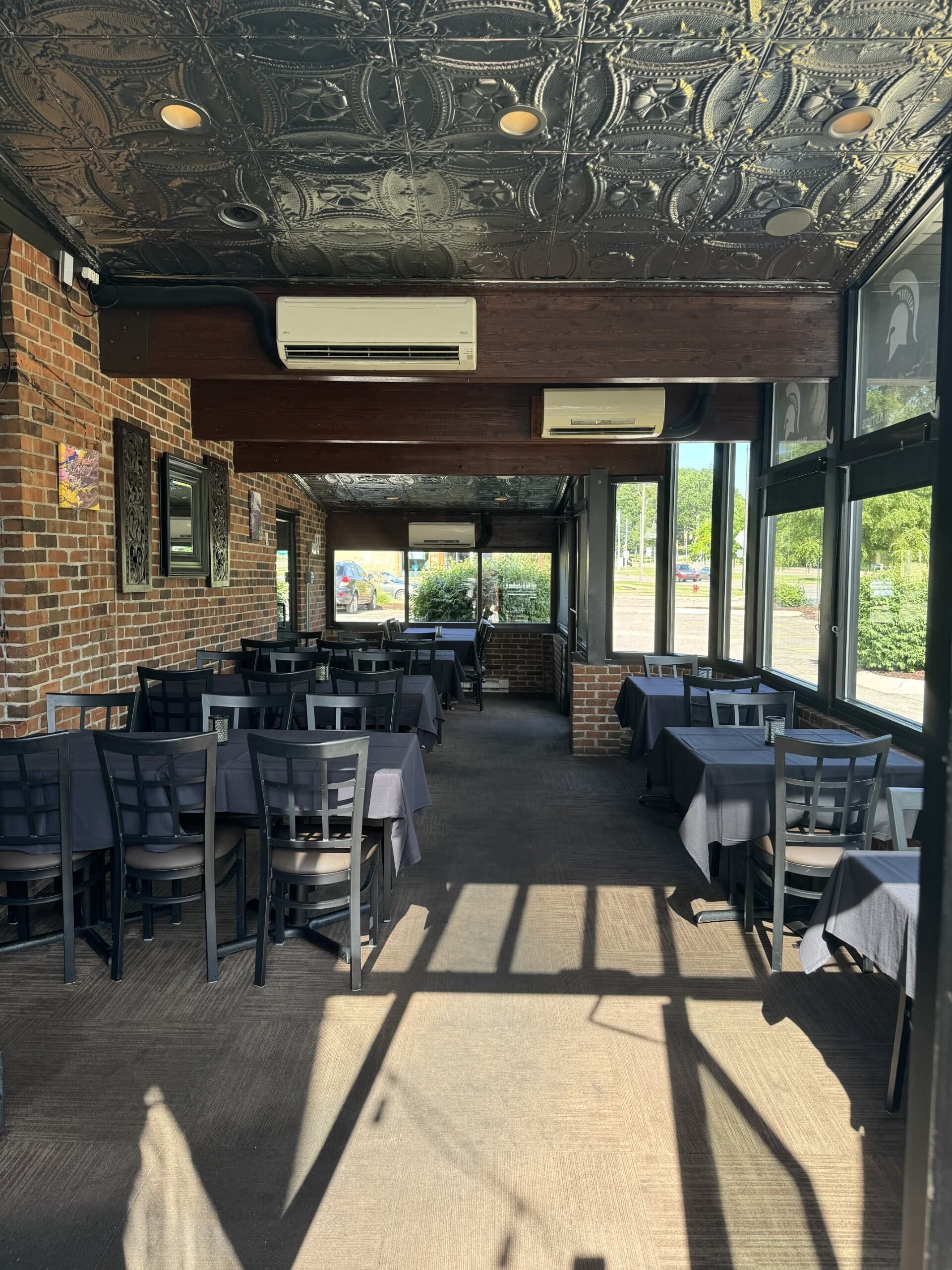 A restaurant with tables and chairs and a black ceiling