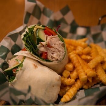 Wrap sandwich and crinkle-cut fries in a basket with checkered paper.