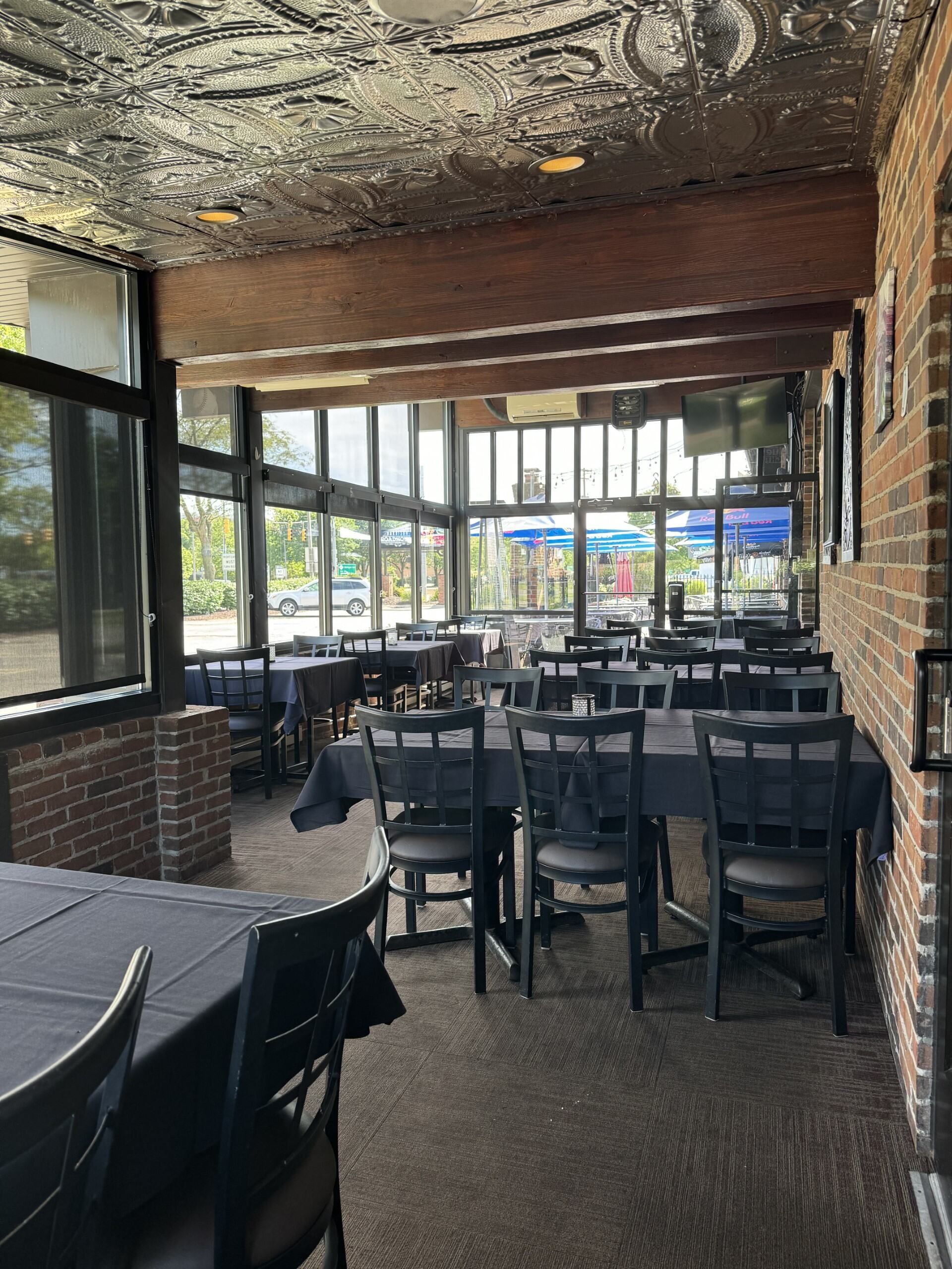 A restaurant with tables and chairs and a lot of windows.