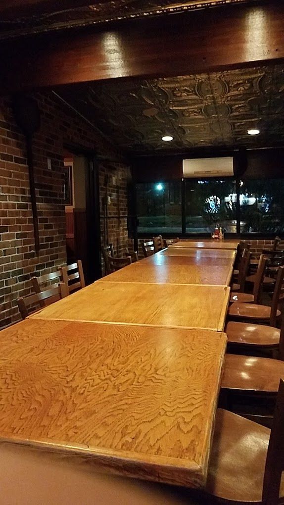 A long wooden table and chairs in a restaurant.