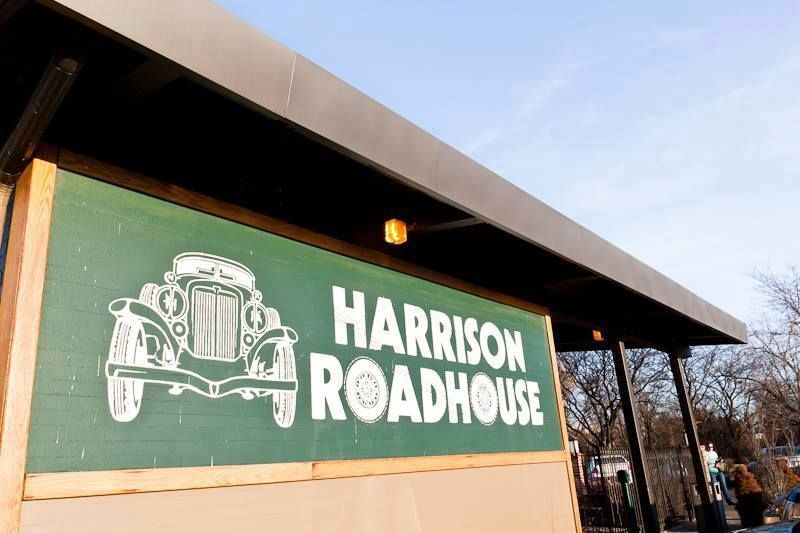 A green sign that says harrison roadhouse on it