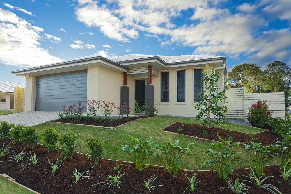 A House With a Large Garage and a Lush Green Yard — Clarence Property Consultants In Wooli, NSW