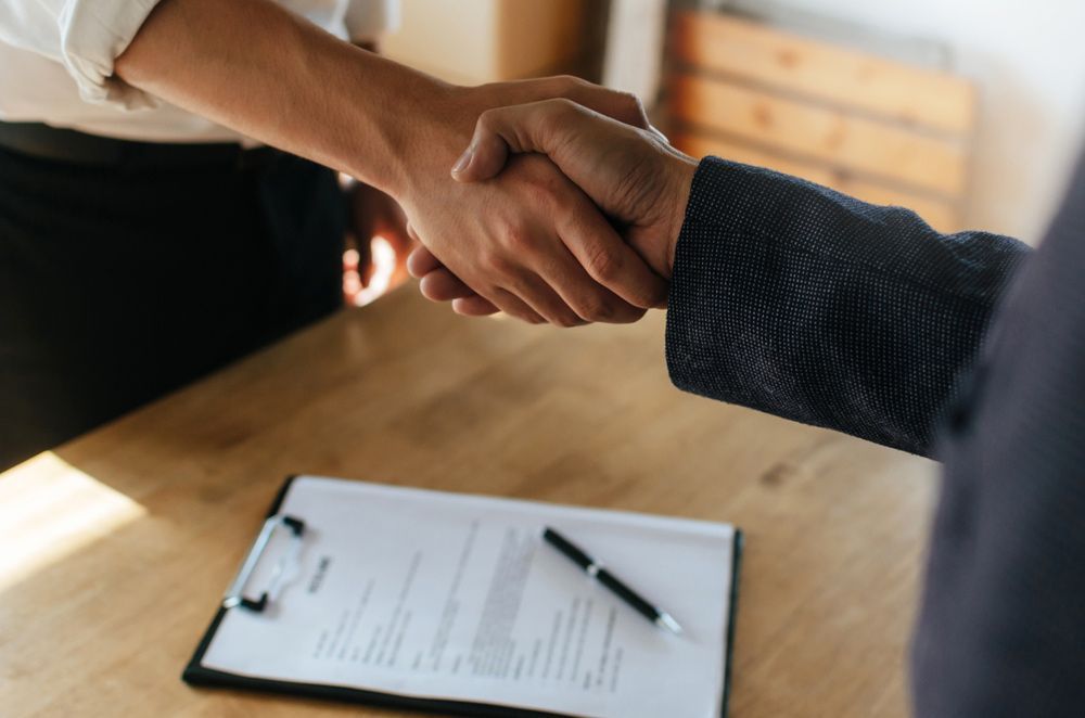 Partnership And Two People Shaking Hands — Compensation & Acquisition in Grafton, NSW