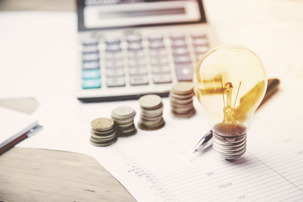 Money, Calculator And Light Bulb On The Financial Papers — Property Valuations for your SMSF in Grafton, NSW