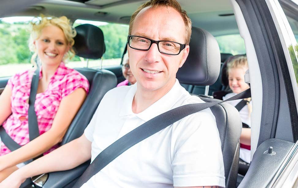 A man and a woman are sitting in the back seat of a car - A Street Automotive