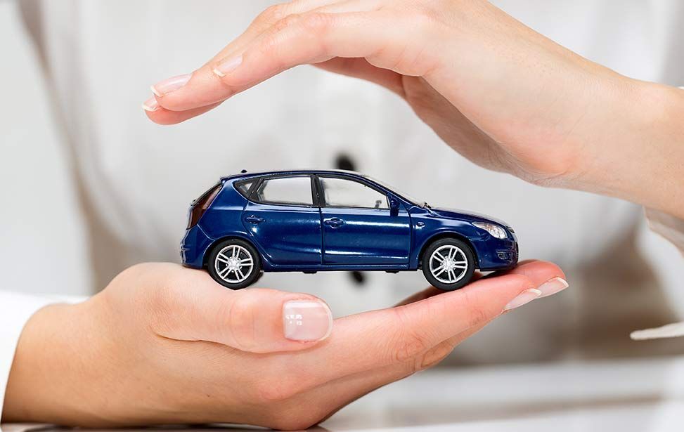 A woman is holding a blue toy car in her hands - A Street Automotive