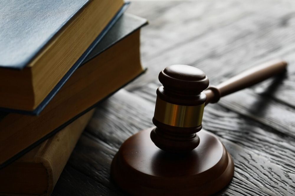 Wooden Gavel on a Stand Next to a Stack of Law Books — Bradley Solicitors in Larrakeyah, NT