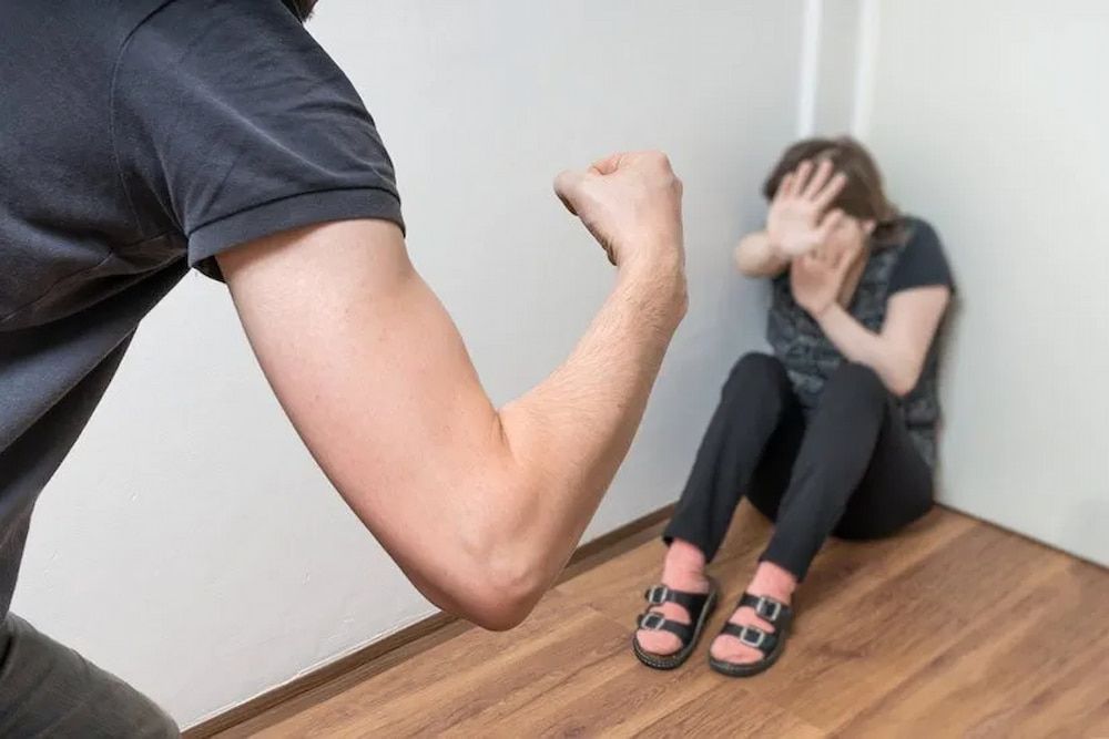 Man With Raised Fist, Woman Crouched in Corner, Covering Face — Bradley Solicitors in Larrakeyah, NT