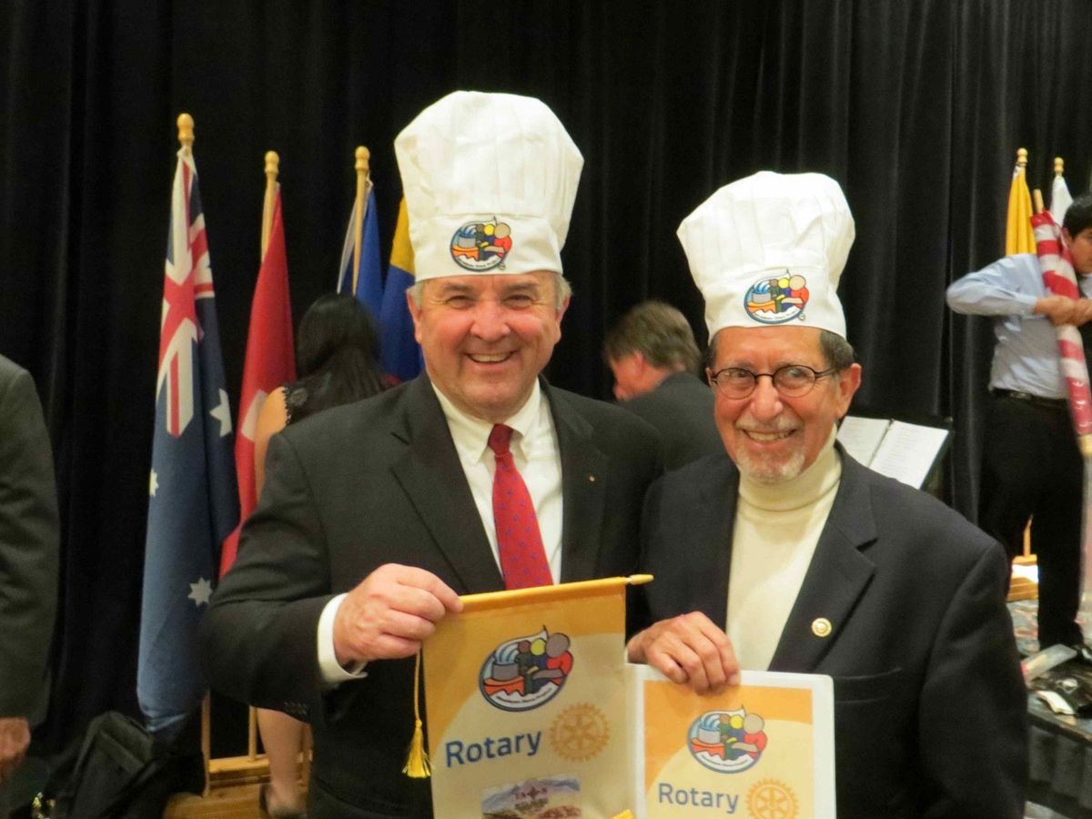 George Basch and Ron Burton President of Rotary International at a conference celebrating Himalayan Stove Project both mean are wearing chefs hats
