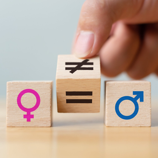 female and male gender icons on dice with hand moving an un-equal sign over to an equal sign in the middle