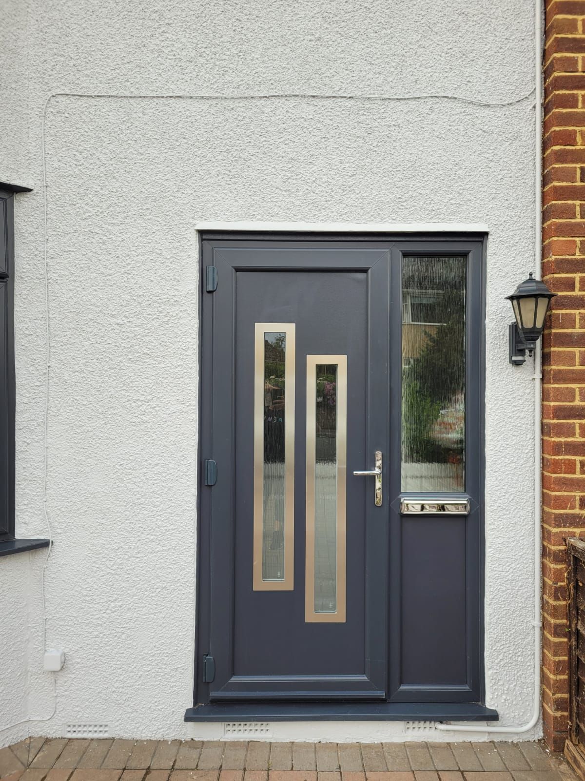 A black door with a brick wall behind it