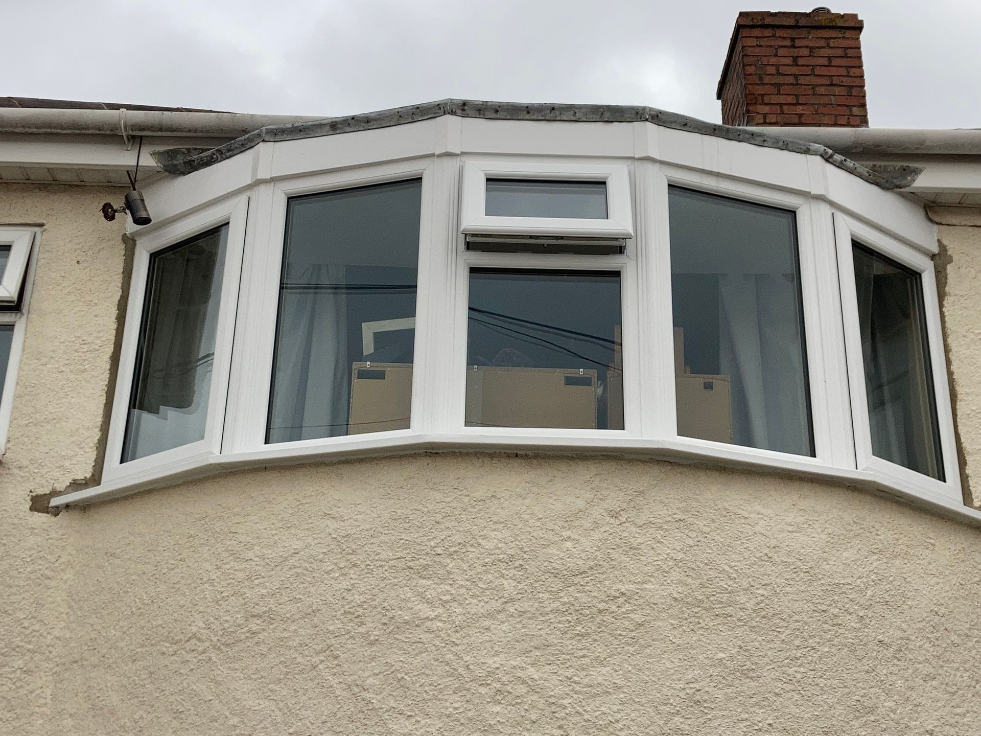 A white bay window on the side of a house.