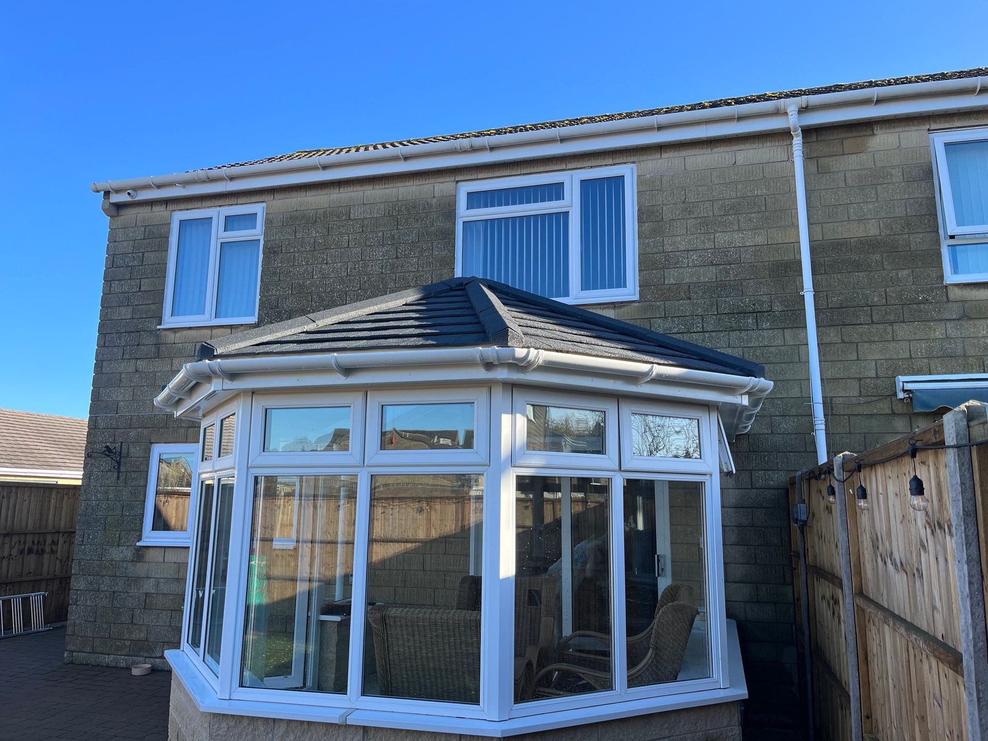 A house with a conservatory on the side of it.