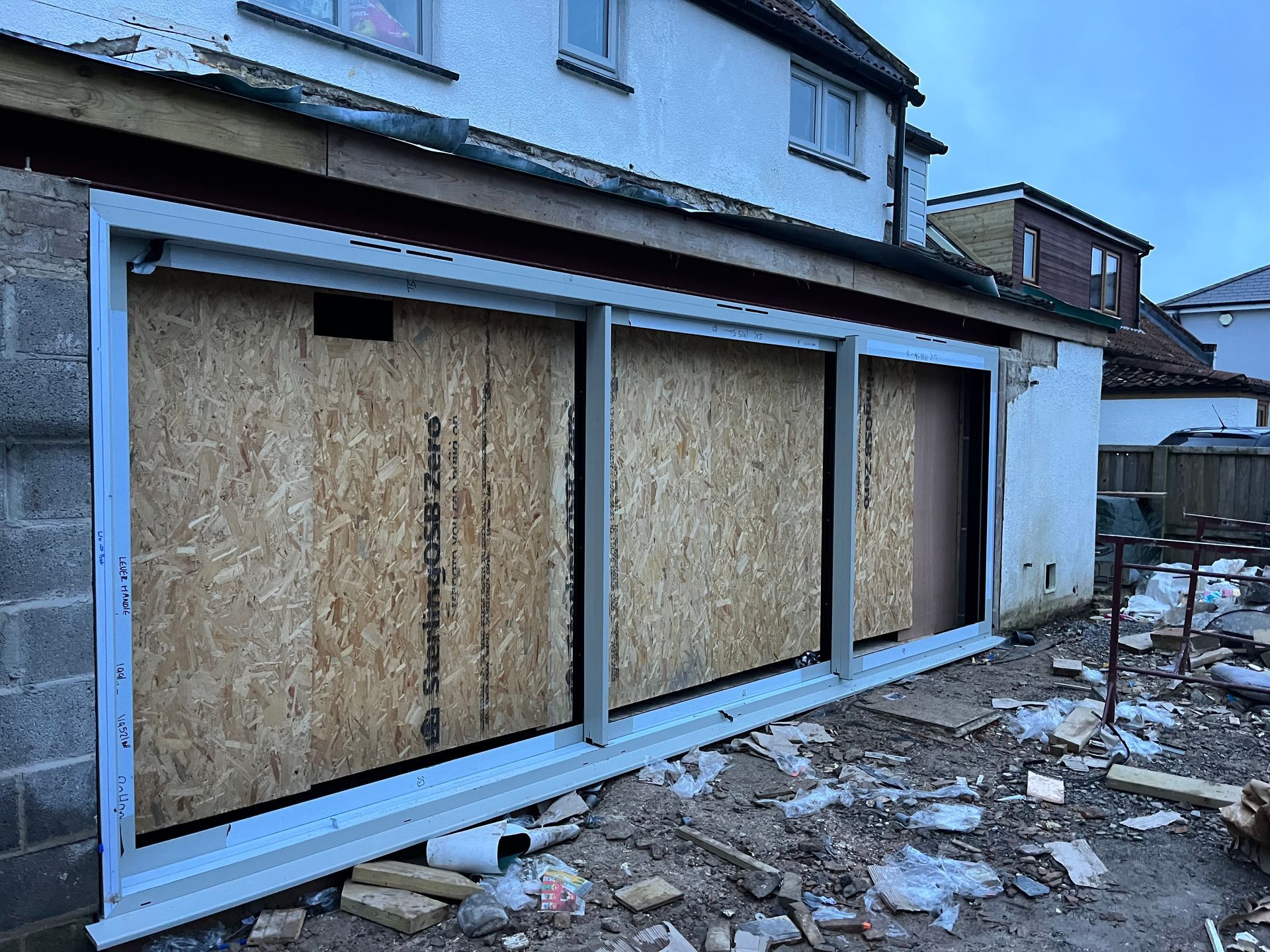 A house is being remodeled and the windows are boarded up.