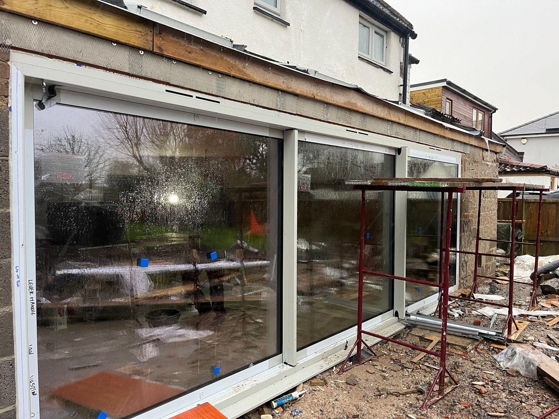 A house is being built with a lot of windows and scaffolding.