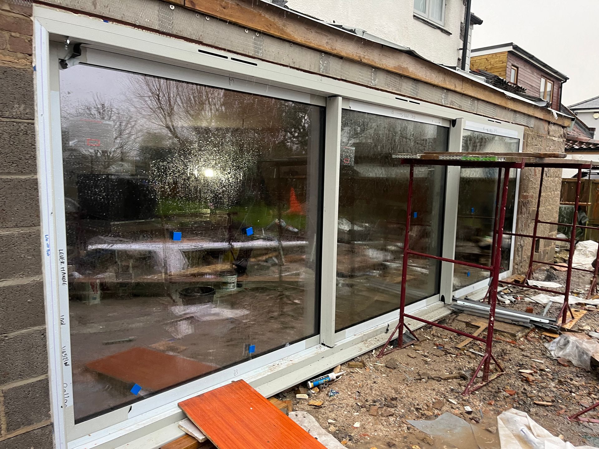 A large window is being installed on the side of a house.